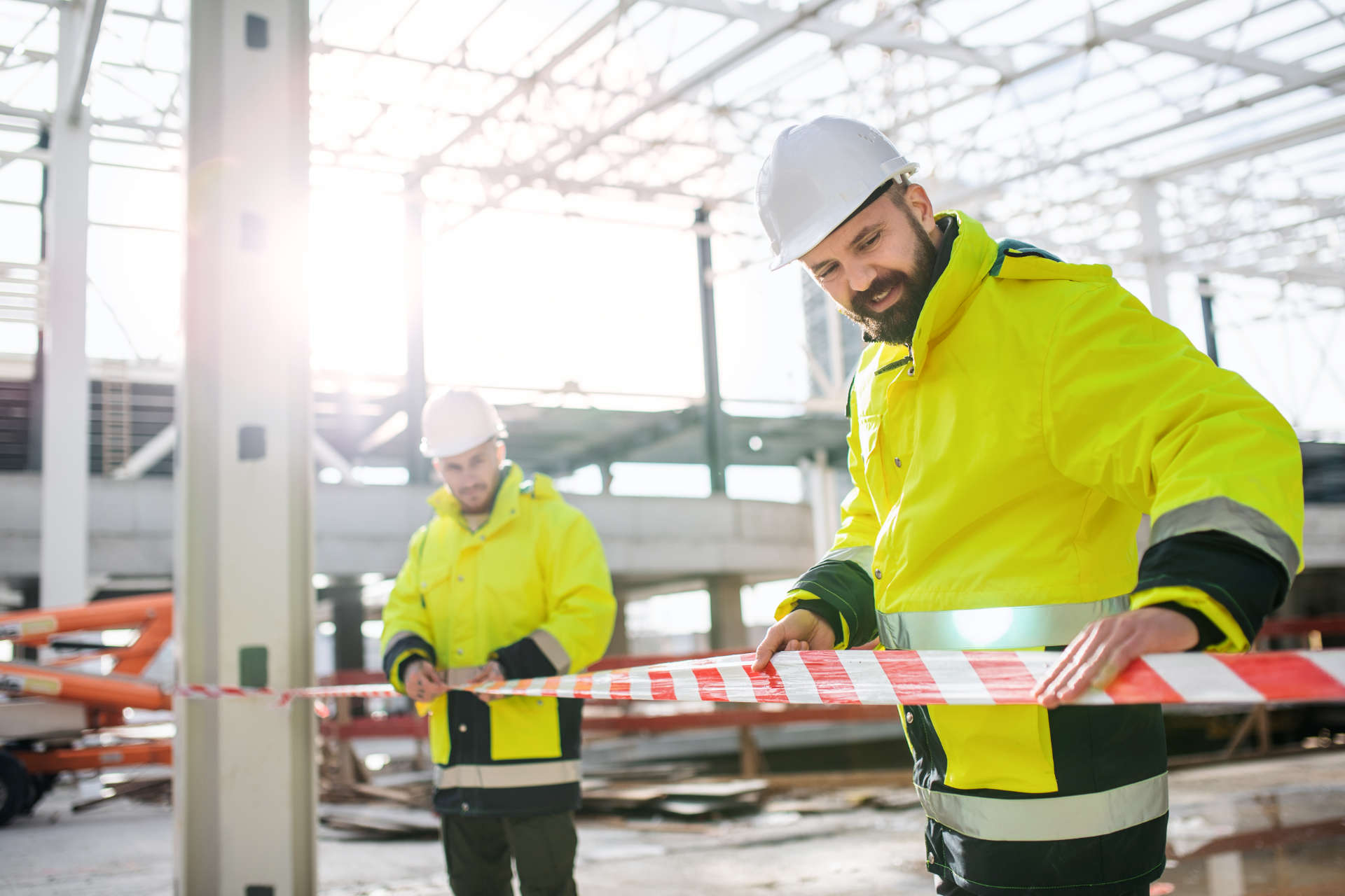 Men workers standing outdoors on construction site, working.