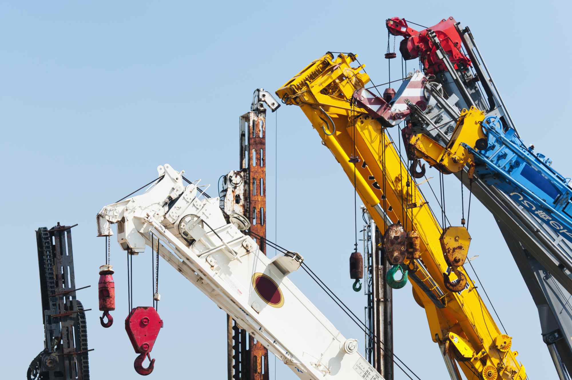 Shipyard Cranes,United States,A group of mobile cranes with hooks and pulleys, dockyard lifting equipment.